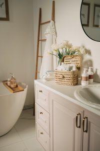 a bathroom with a sink, toilet and a basket of flowers